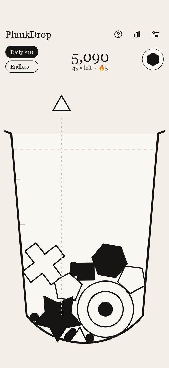 A Daily in play: a pile of ink shapes in the beaker, the next shape held over the rim